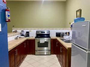 a kitchen with a stove and a refrigerator at Horus Suite Apartamento in San Pedro Sula +17 photos