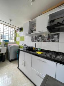 a kitchen with white cabinets and a stove top oven at Suite María Paula in Colombia