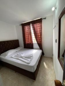 a bedroom with a large bed with a window at Suite María Paula in Colombia