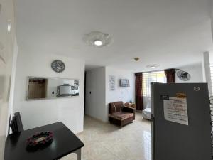 a living room with a table and a refrigerator at Suite María Paula in Colombia