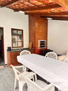 a conference room with a white table and chairs at Pousada Vivenza - Suíte Super Confort 01 in Laguna