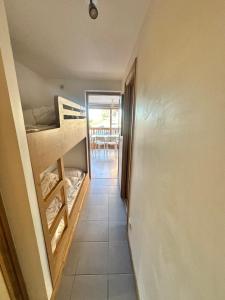 un corridoio di una casa con un letto a castello di Méribel 2 pièces avec cabine, centre, proche commerce et pistes avec parking et wifi état neuf a Les Allues