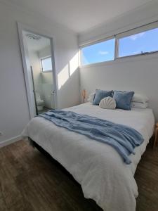 a bedroom with a large bed with a large window at 3rd On Troon in Normanville