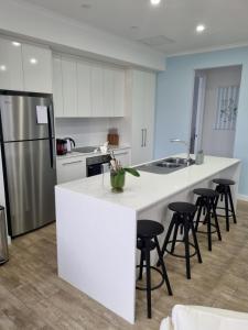 a kitchen with white cabinets and a white counter top at 3rd On Troon in Normanville