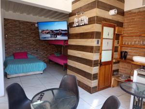 a room with a tv and a table and chairs at HOSTEL SAKAR QUINTERO Beach in Quintero