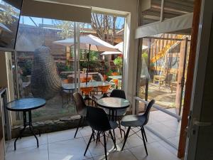 a restaurant with tables and chairs and a patio at HOSTEL SAKAR QUINTERO Beach in Quintero