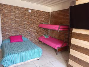 a room with two bunk beds and a flat screen tv at HOSTEL SAKAR QUINTERO Beach in Quintero