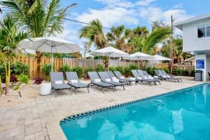 a swimming pool with lounge chairs and umbrellas at Azul Resort Siesta Key in Siesta Key