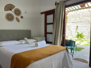 a bedroom with a bed and a large window at Pousada Paracuru Surf in Paracuru