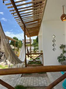 a patio with a hammock in a house at Pousada Paracuru Surf in Paracuru