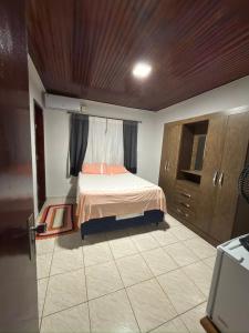 a small bedroom with a bed and a window at Suítes Santa Luzia in Trindade