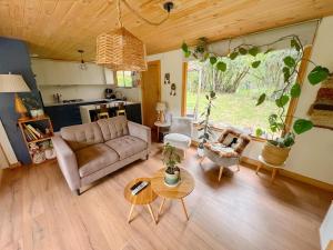 a living room with a couch and a table at Cabaña de Montaña con Río in Puhala