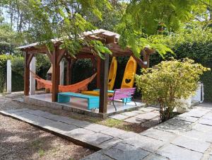 a gazebo with a hammock in a garden at Casa com spa hidromassagem in Florianópolis