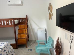 a bedroom with a bunk bed and a blue chair at Pousada Paracuru Surf in Paracuru