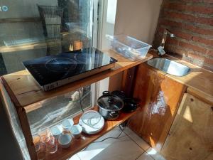 a kitchen counter with a laptop on a wooden shelf at HOSTEL SAKAR QUINTERO Beach in Quintero +29 photos