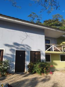 a white house with two doors and some flowers at Casa Hortensia in Nicoya