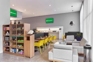 a restaurant with yellow chairs and a table and a counter at Nacional Inn Palmas in Palmas