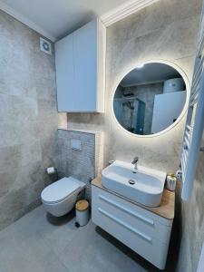a bathroom with a sink and a toilet and a mirror at Apartman Jaćimović in Doboj +35 photos