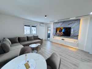 a living room with a couch and a flat screen tv at Apartman Jaćimović in Doboj