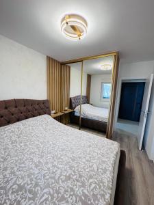 a bedroom with a large bed and a mirror at Apartman Jaćimović in Doboj