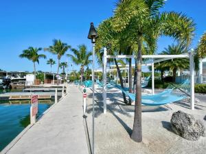a playground with a slide and palm trees next to the water at Tiki Cabana at Key Largo in Key Largo