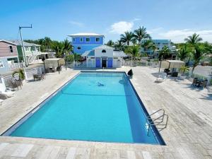a large blue swimming pool in front of a house at Tiki Cabana at Key Largo in Key Largo
