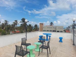 a patio with chairs and tables on a roof at POUSADA GOLFINHO FLECHEIRAS Ce in Trairi