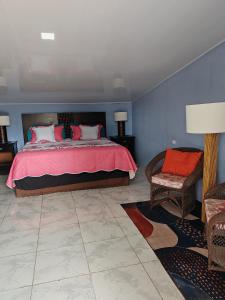 a bedroom with a large bed and a chair at Casa Hortensia in Nicoya