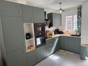 a kitchen with blue cabinets and a stove at Villa Lissya in Morne-à-lʼEau
