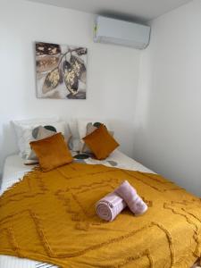 a bed with a yellow blanket on top of it at Villa Lissya in Morne-à-lʼEau