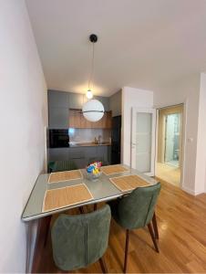 a kitchen and dining room with a table and chairs at White Homes 1BR - Central Point in Podgorica