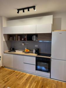 a kitchen with white cabinets and a white refrigerator at Royal apartman Zlatibor in Palisat