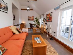 a living room with an orange couch and a table at Baywatch St David's View in Lynton