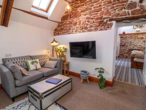 a living room with a couch and a tv at Baywatch St David's View in Lynton