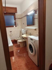 a bathroom with a washing machine and a sink at Casa Lassù in Pieve di Cadore