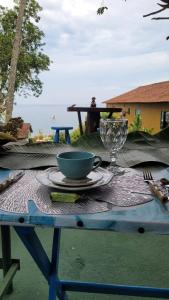 a table with a bowl and a cup and a glass at Suíte Cambucá in Praia do Bananal