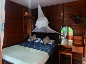 a bedroom with a bed and a desk and a bed sidx sidx sidx at Heiner Beach Homestay in Bunaken