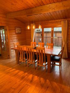 a dining room with a wooden table and chairs at The Fairways, Kenwick Retreats in Louth
