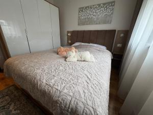 two stuffed animals sitting on top of a bed at Royal apartman Zlatibor in Palisat +10 photos