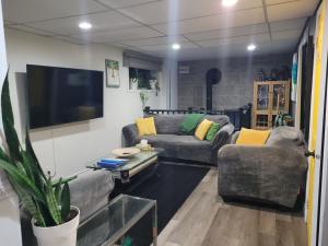 a living room with two couches and a flat screen tv at Stephna555 in Saint-Pascal