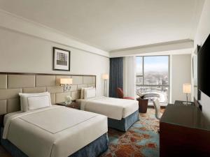 a hotel room with two beds and a window at Swissotel Makkah in Mecca +225 photos