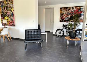 a room with a black chair and a table at Art_Booking . . . by Benoit_B in Duingt