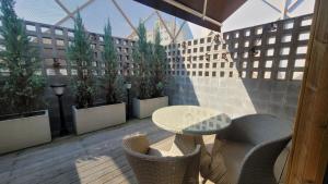 a patio with a table and chairs on a balcony at Hotel Label Seongnam in Seongnam
