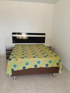 a bedroom with a bed with a floral bedspread at Sítio Moriá in Camaçari