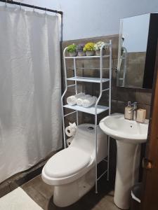 a bathroom with a toilet and a sink at Casa Hortensia in Nicoya +17 photos