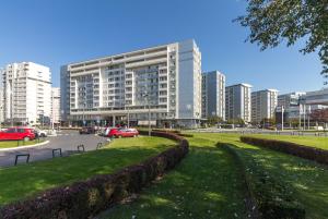 a large building with cars parked in a city at Nevena Belville Apartments in Belgrade