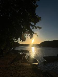 a group of boats sitting on the shore of a lake at Recanto Caraíva in Caraíva