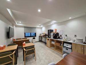 a kitchen with tables and chairs in a room at Haeundae HaeRium Hotel in Busan