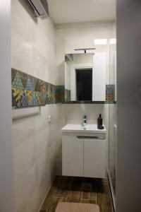 a bathroom with a white sink and a mirror at Lazar Apartman in Čantavir +5 photos
