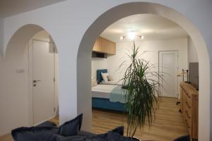 a bedroom with a bed and a potted plant at Lazar Apartman in Čantavir